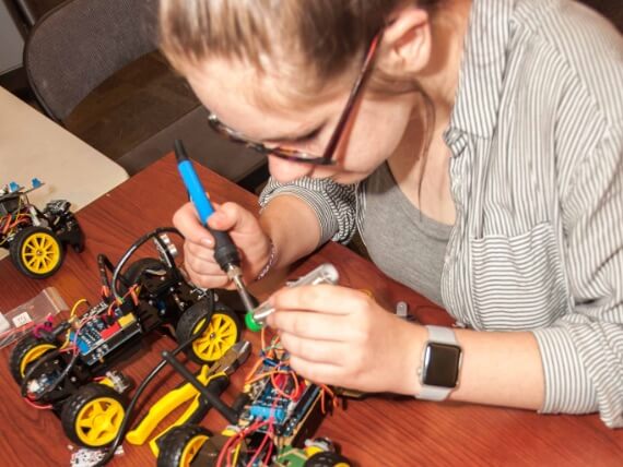 Girl soldering car electronics